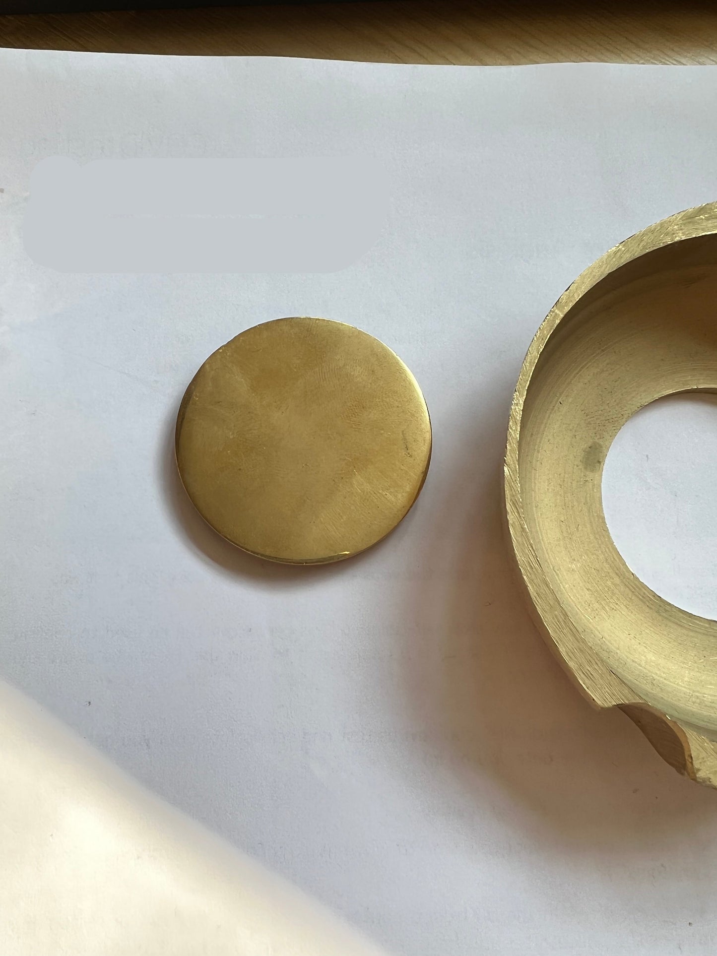 Gold circular object on a white surface with Spire Instrumentation Ltd branding.Dental laboratory denture flask compressor brass parts set used for denture molding and processing, durable dental lab equipment for accurate prosthetic fabrication